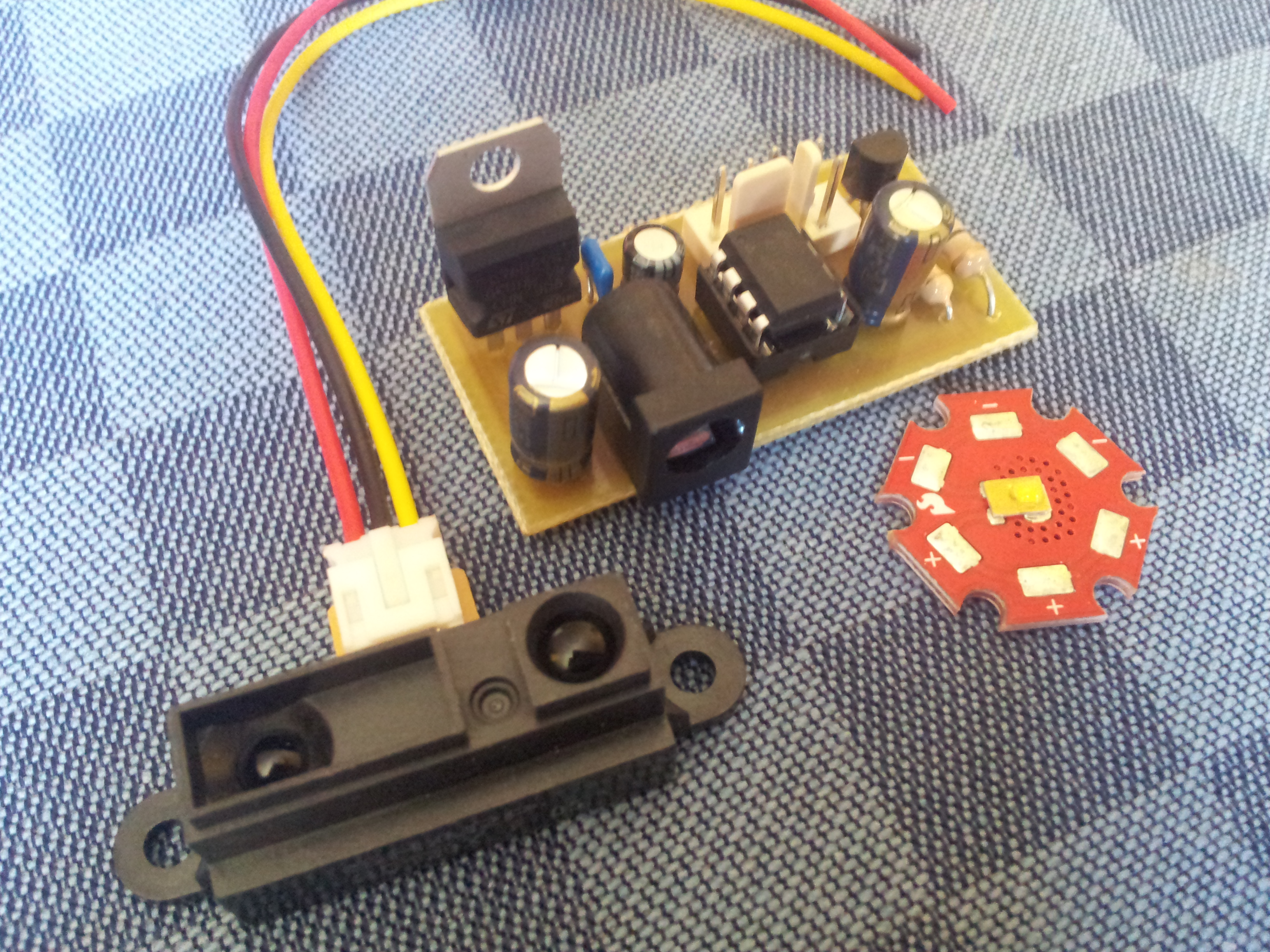 Figure 1. Custom built PCB with all the components soldered, Sharp's IR proximity sensor and Philips' Luxeon Rebel.